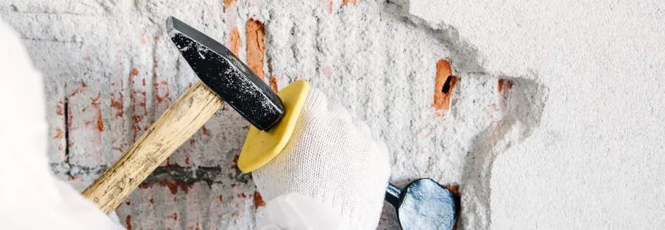 Hand mit Hammer und Meißel